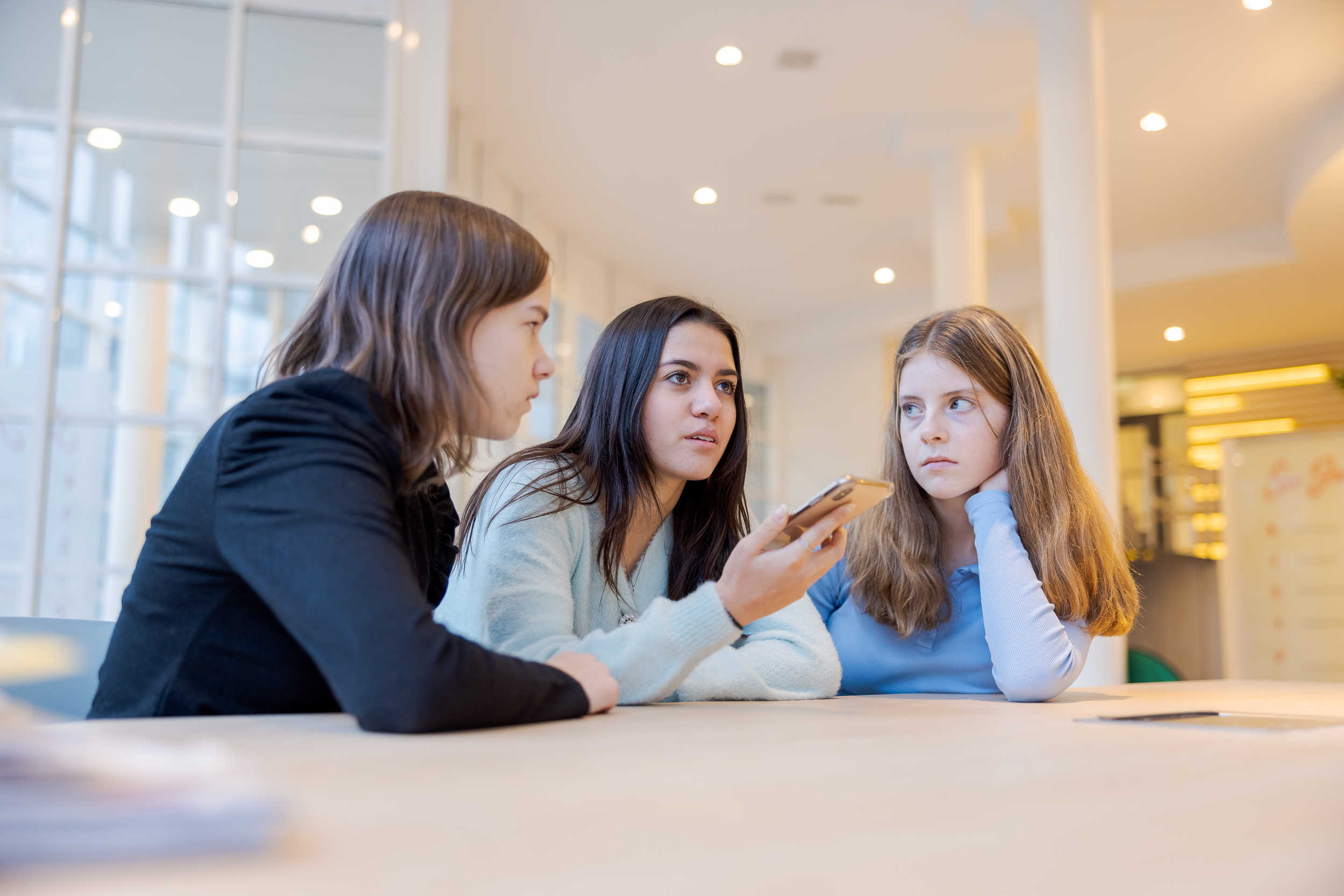 3 meiden praten samen in mobiele telefoon